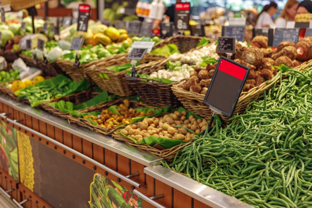 Rows of fresh vegetables on shelf in supermarket, close up